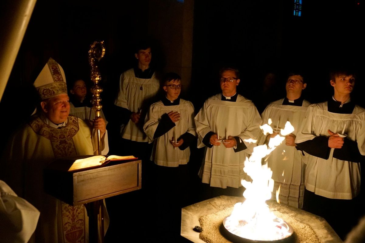 Archbishop Bernard Hebda, left, smiles before blessing the fire and the Paschal candle at the Cathedral of St. Paul in St. Paul, Minn., on Saturday.  (Giovanna Dell'Orto)