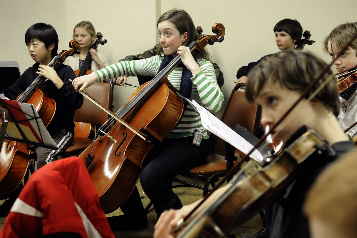 Anna Seppa, center, 12, and members of the Spokane Youth Symphony Intermediate String Orchestra practice  Monday at the Masonic Temple for Sunday’s concert  at the Martin Woldson Theater at The Fox.  (PHOTOS BY DAN PELLE)