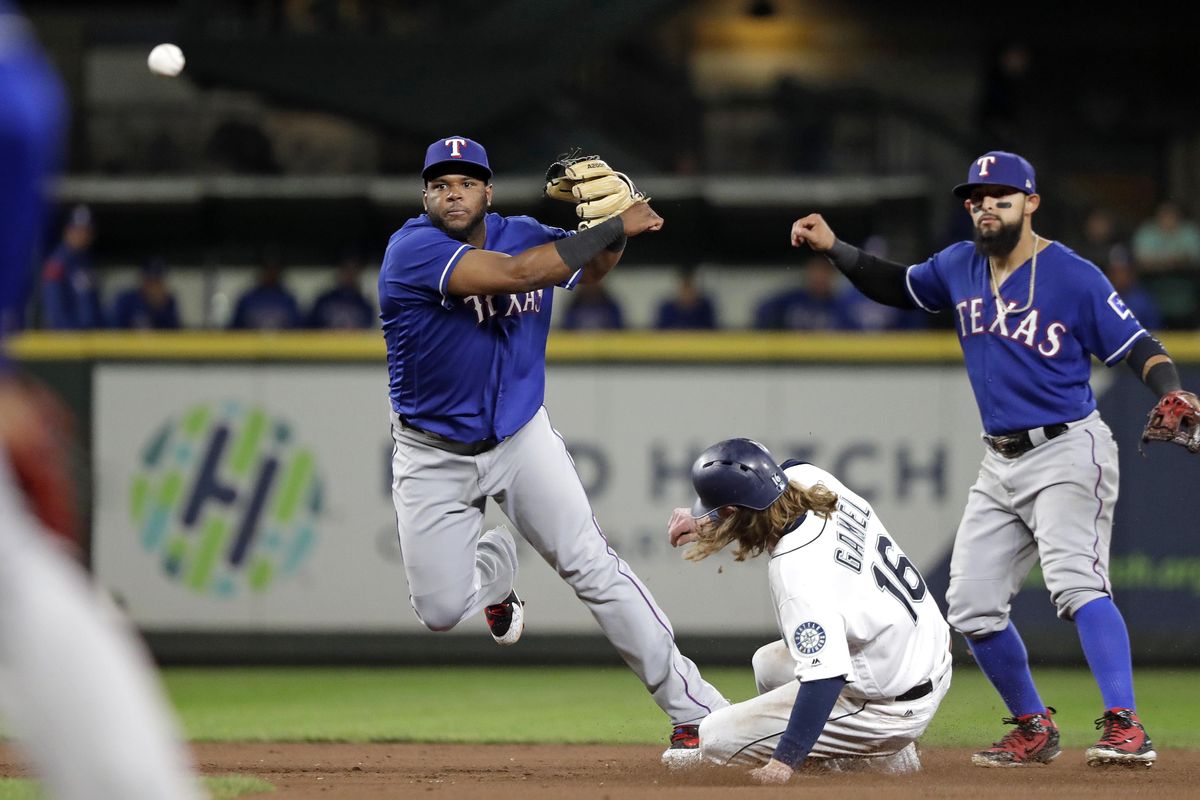 Texas Rangers shortstop Hanser Alberto throws to first after forcing out Seattle’s Ben Gamel  at second base as second baseman Rougned Odor watches during the sixth inning Thursday in Seattle. Kristopher Negron was out at first on the double play. (Elaine Thompson / AP)
