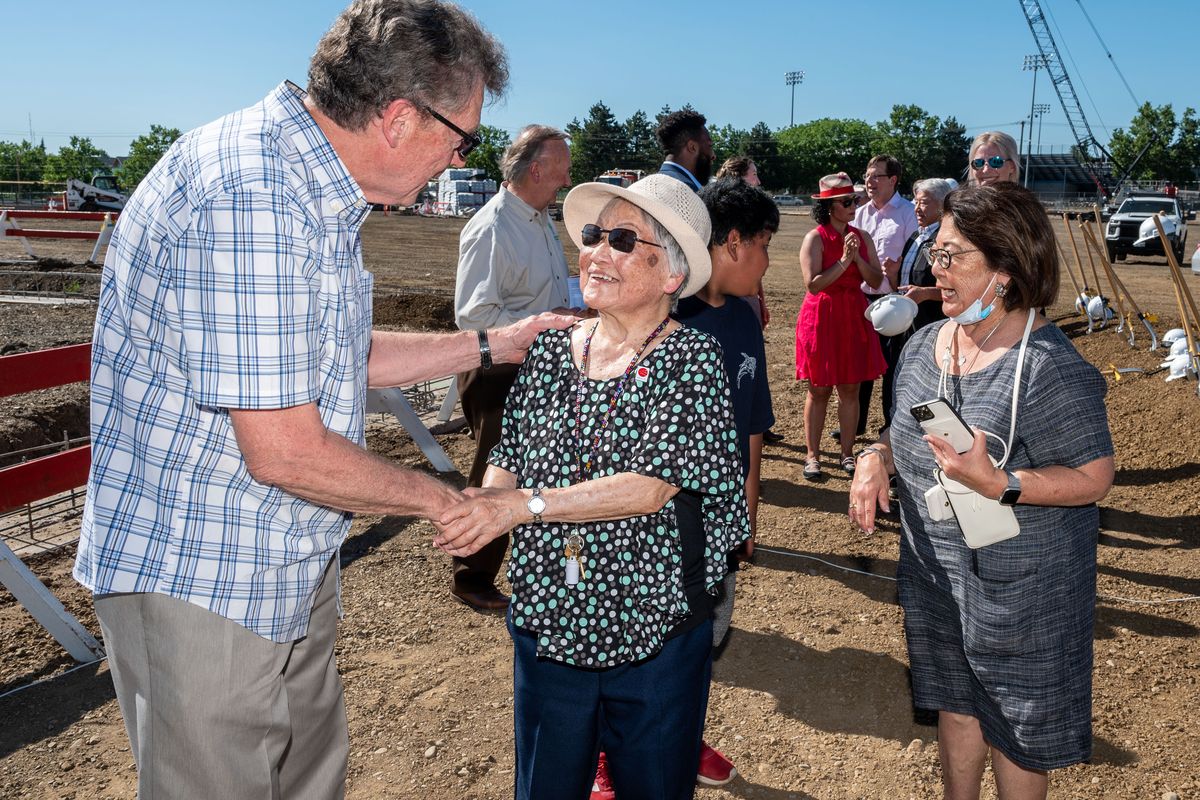 Jim Parry, who taught with Denny Yasuhara for 20 years at Garry Middle School, greets Thelma Yasuhara, the widow of Denny, during the groundbreaking for the new Denny Yasuhara Middle School, Wednesday, June 2, 2021.  (COLIN MULVANY/THE SPOKESMAN-REVIEW)