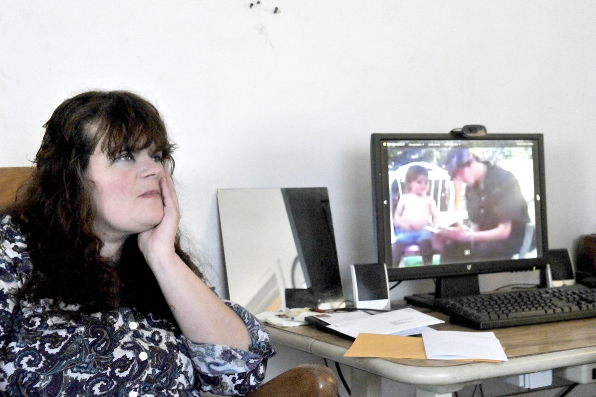 Rebecca Allen, shown at home Dec. 22, grieves the loss of her 18-year-old son, Alex, shown in a photo on the computer monitor at right. Alex drowned in the Spokane River in July after falling off the Post Street Bridge. (Jesse Tinsley)
