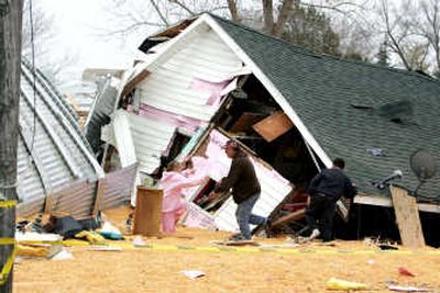 
Family members sift through the remains of Jesse and Jennifer Kellett's home Tuesday after a grain bin collapse the night before spilled 500,000 bushels of corn into the Hillsboro, Iowa, home. Associated Press
 (Associated Press / The Spokesman-Review)