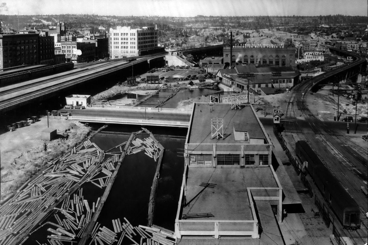 1934: What is now the south side of Riverfront Park was once an area of railroads and a sawmill, with logs stored on the south channel of the Spokane River through downtown. A south leg of the Howard Street Bridge, center left, was opened in early 1931 and cost $36,500. Today, it is being removed and replaced at a cost of $4.7 million. The current Spokane City Hall can be seen in the distance at left. (Spokesman-Review Photo Archive / SR)