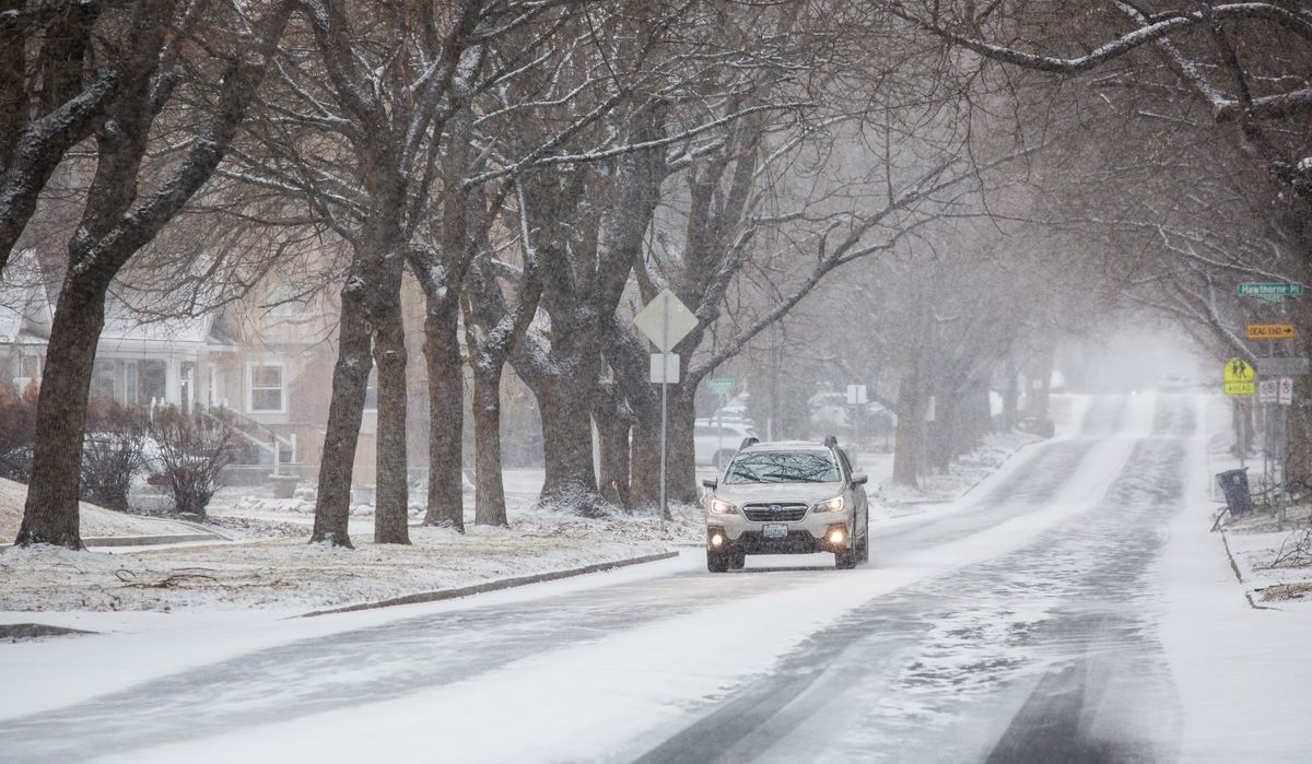 A car heads east to Grand Boulevard as it snows on Sunday in Spokane. Several inches of snow are expected to accumulate by Monday morning.  (Libby Kamrowski/ THE SPOKESMAN-REVIEW)
