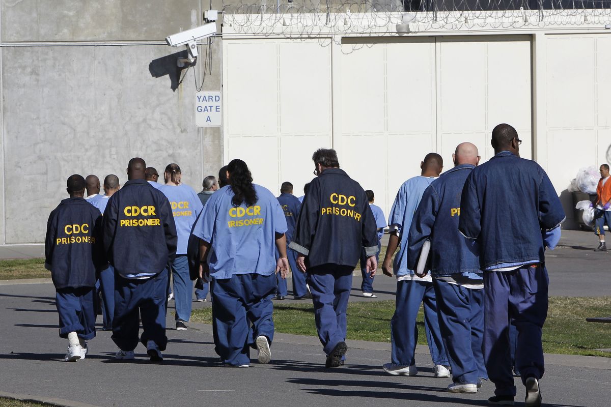 In this Feb. 26, 2013 photo, inmates walk through the exercise yard at California State Prison Sacramento, near Folsom, Calif. California is giving 76,000 inmates, including violent and repeat felons, the opportunity to leave prison earlier as the state aims to further trim the population of what once was the nation