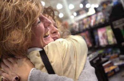 
Customer service representative Linda Saffle hugs co-worker Seasun Bovee at Fred Meyer recently. Linda goes in to pick up her paycheck every week and to say hello. 
