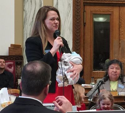In this March 2017, photo, provided by Rep. Kimberly Dudik, Dudik speaks on the floor of the legislature holding her newborn son Marcutio in Helena, Mont. As experts predict another banner year of women running for office, hurdles remain particularly for those like Dudik who have young children. Only six states have laws specifically allowing the use of campaign funds for child care. In most states, including Montana, the law is silent on the issue and up to interpretation by state agencies or boards. (Rep. Nate McConnell / Associated Press)