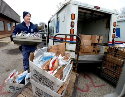 Letter Carrier Steve Homa loads up his mail truck with letters and packages for delivery at the post office in Chatham, Illinois, on East Walnut Street Tuesday Dec. 13, 2022.  (Thomas J. Turney / USA TODAY)