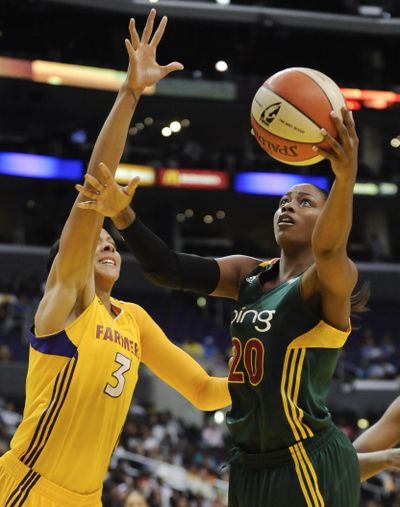 Storm forward Camille Little (20) gets by Sparks forward Candace Parker for a bucket. (Associated Press)