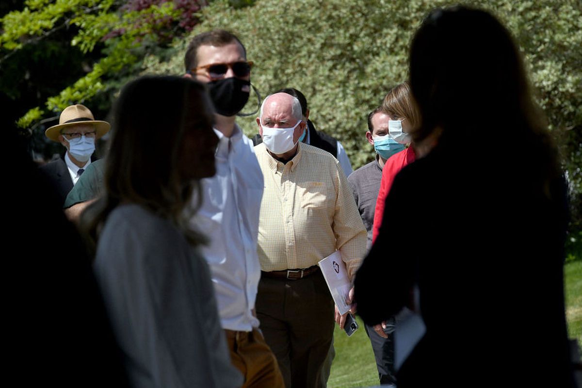 U.S Department of Agriculture Secretary Sonny Perdue, center in white mask, walks next to U.S. Rep Cathy McMorris Rodgers after a tour of Eat Good Cafe that is part of the department’s Farmers to Families Food Box program enacted during the coronavirus pandemic. They then addressed the crowd during a news conference Thursday in Liberty Lake.  (Kathy Plonka/The Spokesman-Review)
