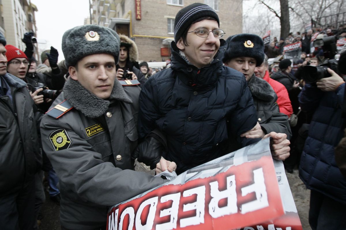 Russian police officers detain a Mikhail Khodorkovsky supporter outside a courtroom in Moscow Monday.  (Associated Press)