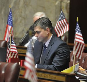 OLYMPIA -- Flanked on all sides by flags, Sen. Mike Baumgartner, R-Spokane, listens to speeches on a resolution on May 4, 2011 honoring the military and Barack Obama for the mission that killed Osama bin Laden. The flags were placed on every senator's desk for the morning session. (Jim Camden/The Spokesman-Review)