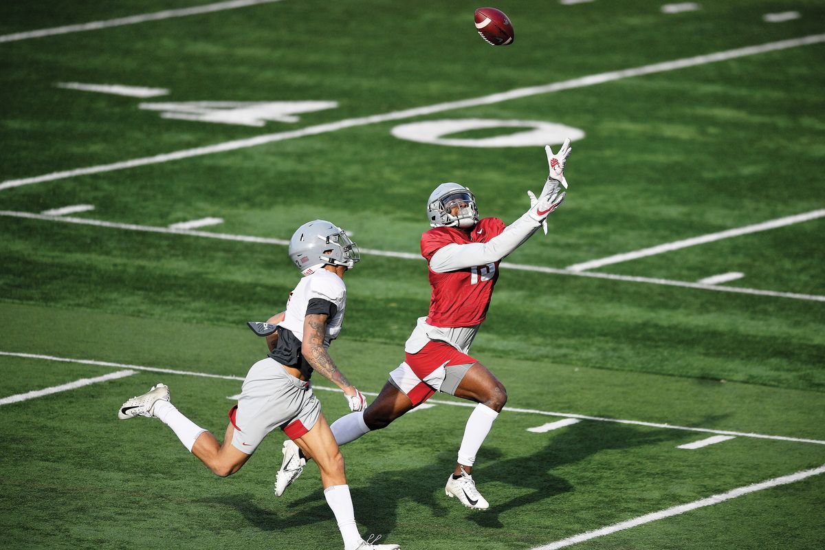 WSU receiver Donovan Ollie (13) brings in a long pass against defensive back Derrick Langford (2) during a spring college football practice on Thursday, April 8, 2021, on WSU