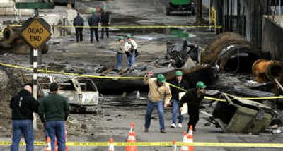 
Inspectors pass under caution tape as onlookers check out the damage of Saturday's propane tank explosion at Atlas Castings and Technology foundry in Tacoma on Monday. Associated Press
 (Associated Press / The Spokesman-Review)