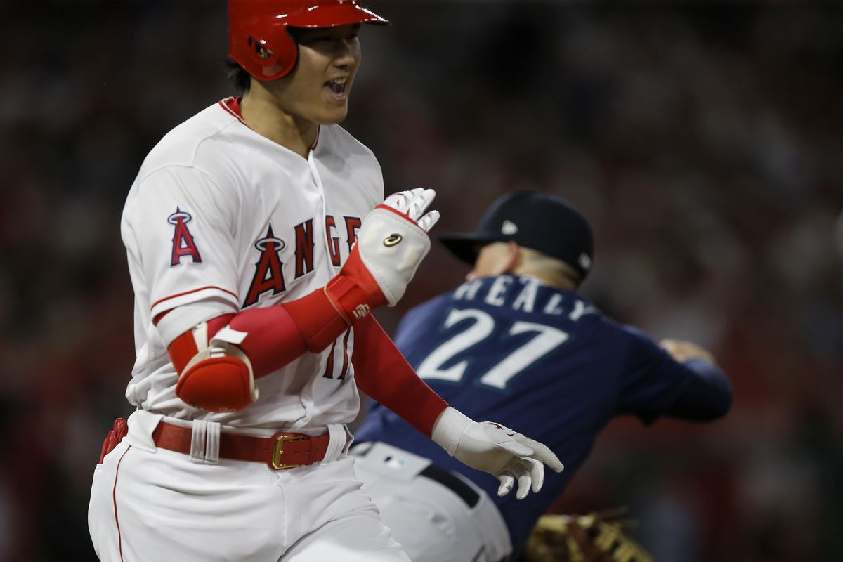 Los Angeles’ Shohei Ohtani reacts after he reached first base, as the ball gets by Seattle Mariners first baseman Ryon Healy for an error by second baseman Dee Gordon during the fourth inning Tuesday. (Alex Gallardo / AP)