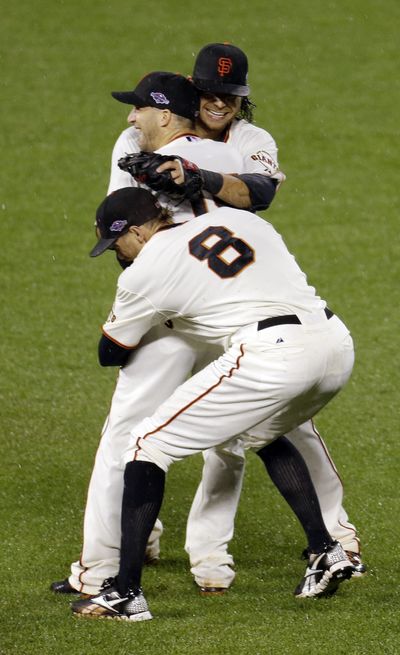 Marco Scutaro, middle, Hunter Pence (8) and Brandon Crawford of the San Francisco Giants celebrate their trip to the World Series after Game 7’s final out. (Associated Press)