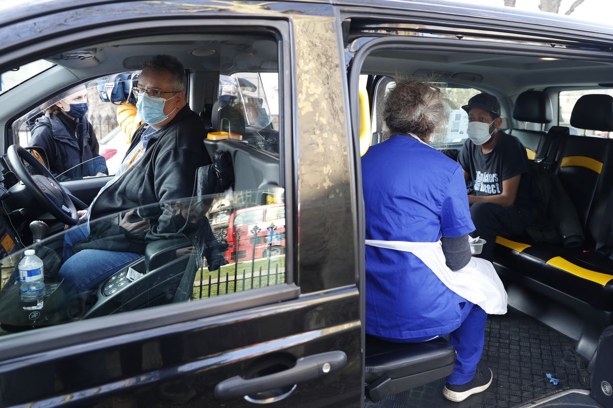 Dr Tamara Joffe prepares to administer a Covid-19 jab using the AstraZeneca vaccine to Leslie Reid in the back of a London Taxi cab during the pilot project of pop up vaccination drive 