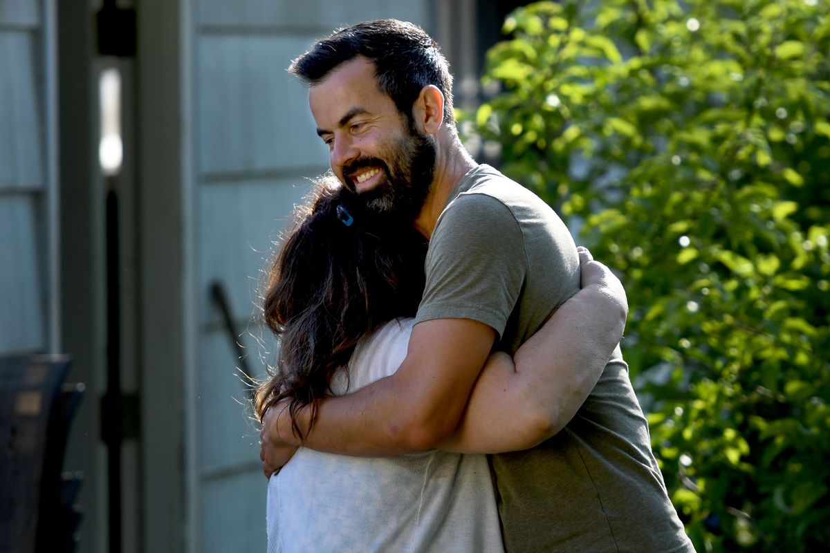 Adam Schlüter hugs Annetta Willey during Monday night dinner at his house in Coeur d’Alene on May 17. Informal invitations to dinners at his home have led to lasting friendships. (KATHY PLONKA/THE SPOKESMAN-REVIEW)