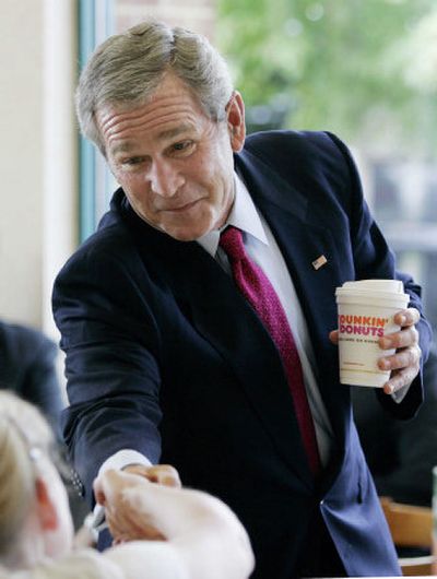 
President Bush greets customers during an unscheduled stop at a Dunkin' Donuts restaurant in Alexandria, Va., on Wednesday. 
 (Associated Press / The Spokesman-Review)