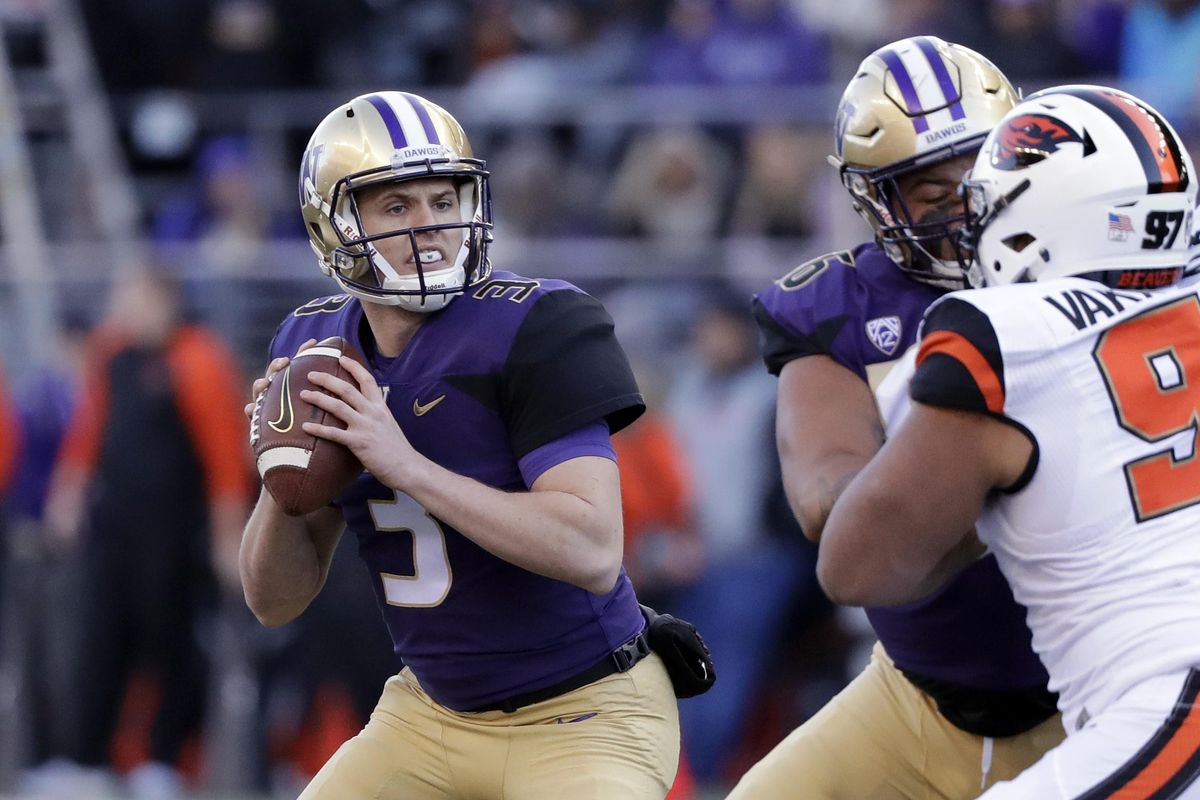 Washington quarterback Jake Browning, left, drops back to pass against Oregon State in the first half of an NCAA college football game Saturday, Nov. 17, 2018, in Seattle. (Elaine Thompson / AP)