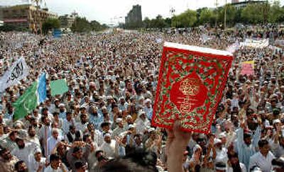 
A Pakistani holds a copy of the Quran, Islam's holy book,  at a rally Friday to protest alleged desecration of the Quran at the Guantanamo prison in Cuba. 
 (Associated Press / The Spokesman-Review)
