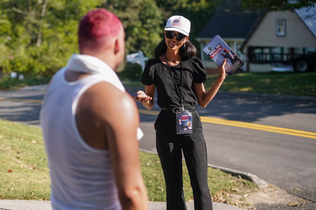 Alysia McMillan speaks with a potential voter while canvassing on behalf of Elon Musk’s America PAC on Sunday in Dalton, Ga. The PAC is working to turn out voters in battleground states. M 