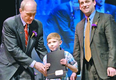 Spokane Mayor Dennis Hession nudges Chase Youth Leadership Award winner Bailey Wills, 7, forward for a photo with Hession and Spokane County Commissioner Todd Mielke at the Chase Youth Awards ceremony  Tuesday. 
 (Holly Pickett / The Spokesman-Review)