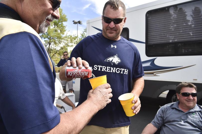Montana State fan Mark D’Agostino, right, pours a beer for friend Jerry Johnson before the start of a college football game against Idaho on Thursday, Sept. 1, 2016, outside the Kibbie Dome in Moscow. The University of Idaho is asking Idaho’s State Board of Education to amend its alcohol permit policy to allow pre-game alcohol sales in the Fan Zone and tailgating in Kibbie Dome parking lots. (Tyler Tjomsland / The Spokesman-Review)