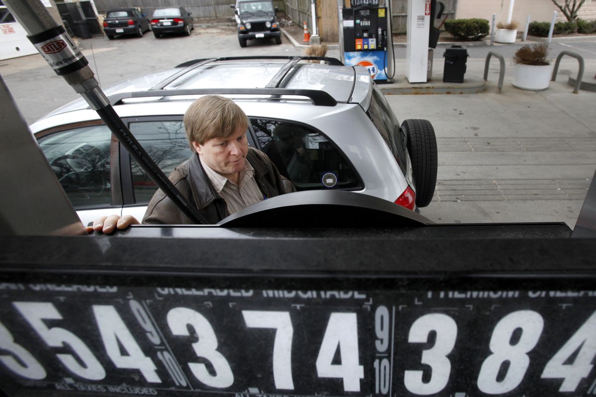 Jeff Pearson, of Needham, Mass., keeps his eye on the pump while filling his tank with gas at a Gulf station, in Newton, Mass., a couple of weeks ago.