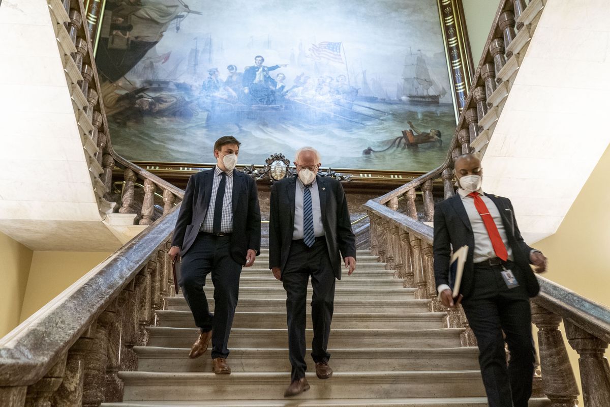 Senate Budget Committee Chairman Bernie Sanders, I-Vt., center, walks towards the Senate floor as the Senate moves from passage of the infrastructure bill to focus on a massive $3.5 trillion budget resolution, a blueprint of President Joe Biden
