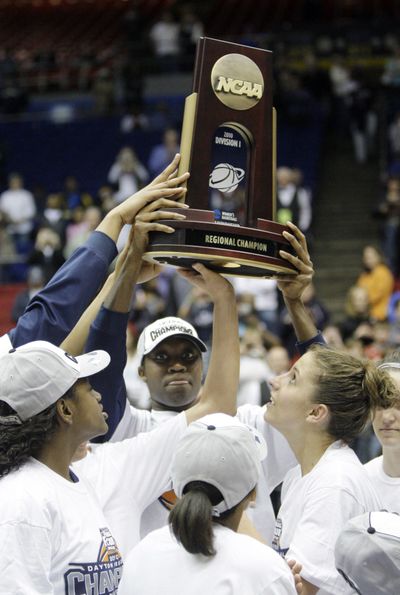 The Connecticut Huskies hoist the trophy Tuesday after winning the NCAA Dayton Regional final, 90-50 over the Florida State Seminoles. (Associated Press)