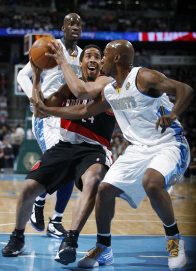 Andre Miller, center, drives between Denver’s Chauncey Billups, front, and Johan Petro. Denver won 109-92. (Associated Press)