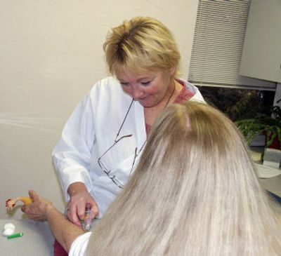 
Barb Smith, a phlebotomist for 26 years, takes a blood sample.
 (Mike Kincaid Handle Extra / The Spokesman-Review)