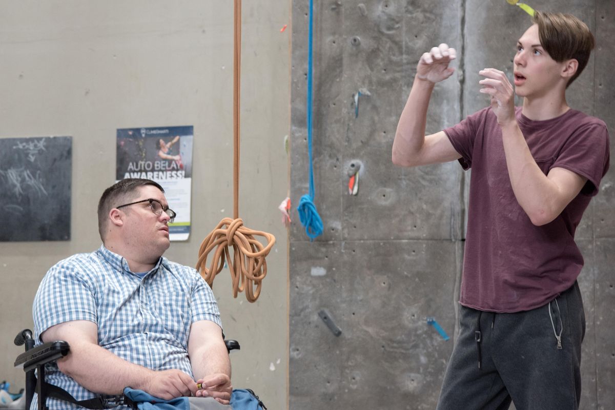 Josh Jackman, left, listens as Aaron Dubbels explains a sequence of climbing moves on Monday May 20, 2019. In 2007 Jackman was hit by a drunk driver nearly dying. Since then, Jackman has trained several generations of climbers in the Spokane area. His coaching focuses heavily on the mental aspects of climbing. (EEli Francovichh / SR)