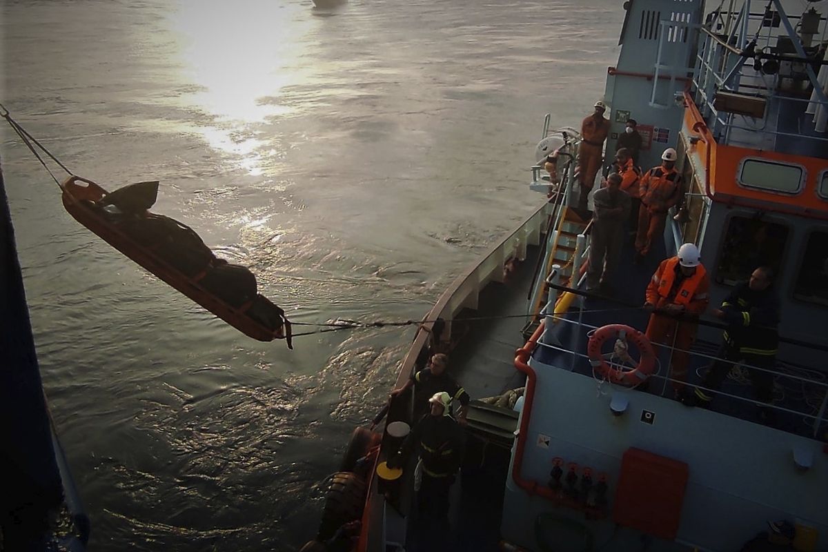 Firefighters remove a body from the Italian-flagged Euroferry Olympia, which is on fire for third day, in the Ionian Sea near the Greek island of Corfu, on Sunday, Feb. 20, 2022. A survivor has been rescued Sunday morning from the stern of a still burning passenger ferry, Greece
