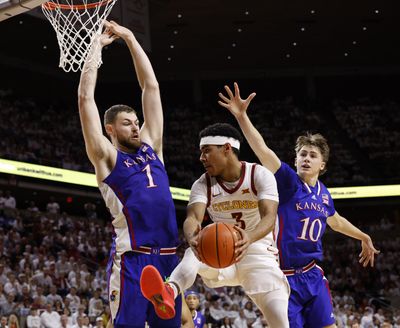 Iowa State's Tamin Lipsey (3) looks to pass the ball around Kansas' Hunter Dickinson (1) and Johnny Furphy (10) in the first half at Hilton Coliseum on Saturday, Jan. 27, 2024, in Ames, Iowa.   (Tribune News Service)