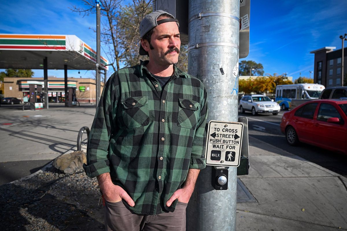 Musician Matt Mitchell, a singer-songwriter from Spokane, stands at the corner of Second Avenue and Division Street on Friday in downtown Spokane. The location echoes his song “Bootstrap Nation” about the hard-luck cases that hang around the neighborhood there.  (Jesse Tinsley/The Spokesman-Review)