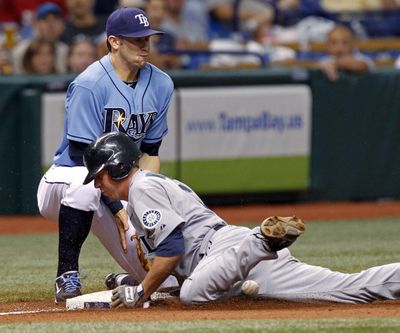 Josh Wilson slides safely into third before the throw reaches Tampa Bay’s Evan Longoria in the fifth inning. Michael Saunders drove him in. (Associated Press)
