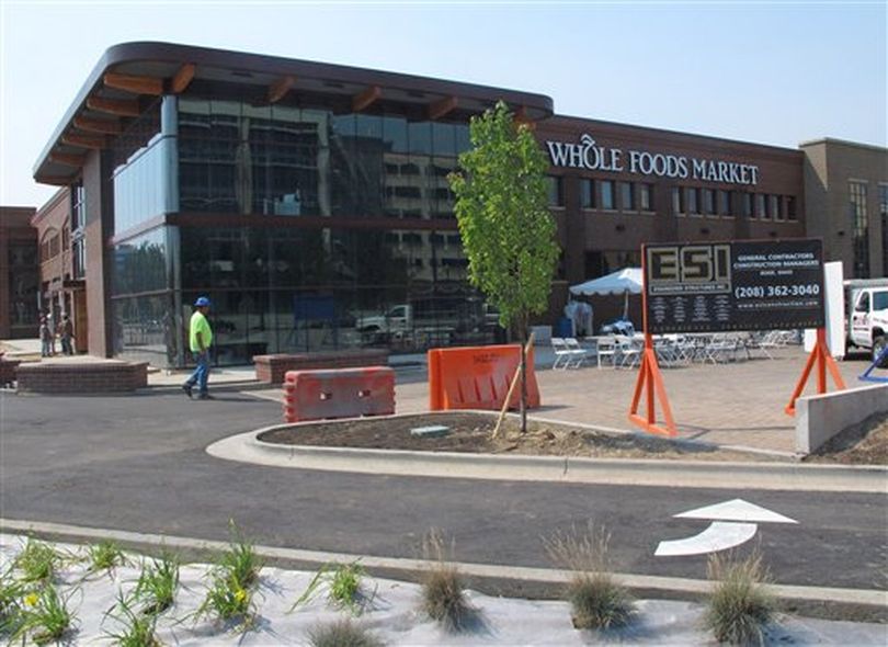 In a photo made Wednesday Aug. 29, 2012, construction workers finish the parking lot of the soon-to-open Whole Foods Market in Boise, Idaho. Across the country, aggressive expansion plans by Whole Foods and specialty grocer Trader Joe's, among others, are forcing independent food co-ops, the cradle of the organic retail trade, with roots dating back to the 1970s, to make changes to stay relevant. (AP / John Miller)