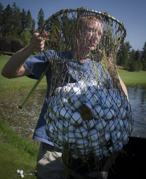 Brett Siddoway, 18, holds up a fishing net full of golf balls he gathered from the aquatic driving range at MeadowWood Golf Course on July 3. Siddoway has been a range hand at the course the last three summers. (Colin Mulvany)