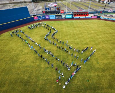 Invited to Avista Stadium by the Spokane Indians baseball organization, Spokane area Seahawks fans gather on the outfield grass to spell out “12”, the reference to the team’s fans as the twelfth man on the field Friday to celebrate the NFC champions’ appearance in the Super Bowl this coming Sunday in San Francisco.  (Jesse Tinsley/THE SPOKESMAN-REVIEW)
