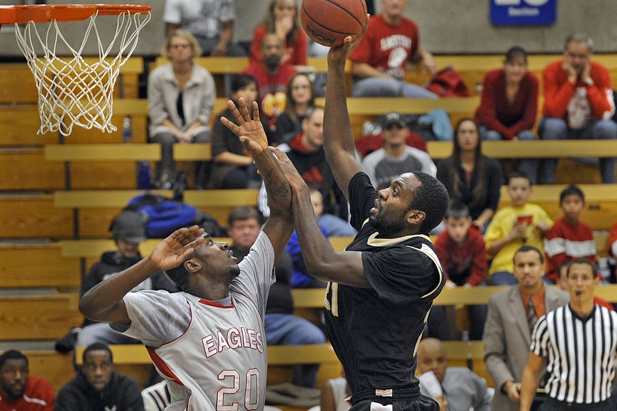 Luiz Toledo puts up a shot in the lane and scores over the defense of EWU’s Tremayne Johnson in Saturday afternoon’s game.  (Christopher Anderson)