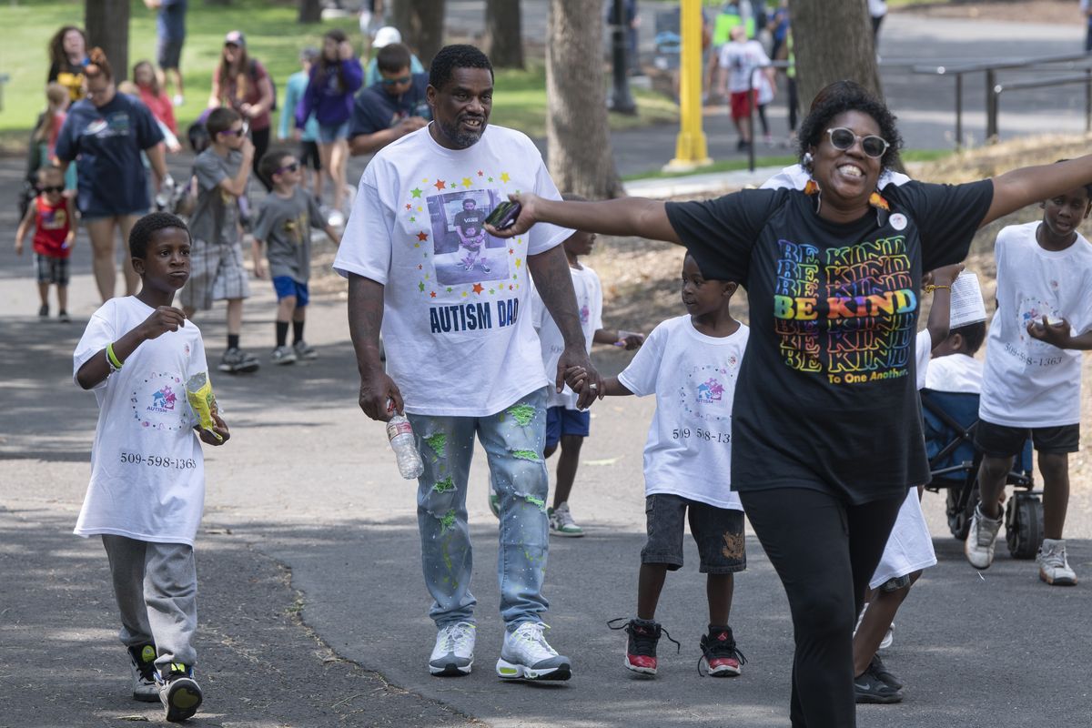 Simon Brown wears his “Autism Dad” t-shirt and walks with extended family members Cevin Richie, 8, left, and Wiley Richie, 5, third from left. At right is the boys’ mother, Ladonna Richie, walking to the finish line of the Steps for Autism walk in Riverfront Park on Sunday. Brown’s son, pictured on his shirt, is with other family members walking behind them. The ISAAC Foundation organized the walk to bring out families affected by autism for a social event and to raise awareness.  (Jesse Tinsley/THE SPOKESMAN-REVI)