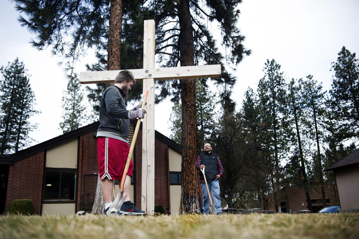 Whitworth Community Presbyterian Church supervisor Joe Alvarez, right, smiles as Steve Hinkle positions a cross for Ash Wednesday on Feb. 10, 2016, at the church in Spokane. Ash Wednesday marks the beginning of Lent. Hinkle said the church will paint the cross purple later in the day. The cross will be be painted black on Maundy Thursday and white on Easter Sunday. (Tyler Tjomsland / The Spokesman-Review)