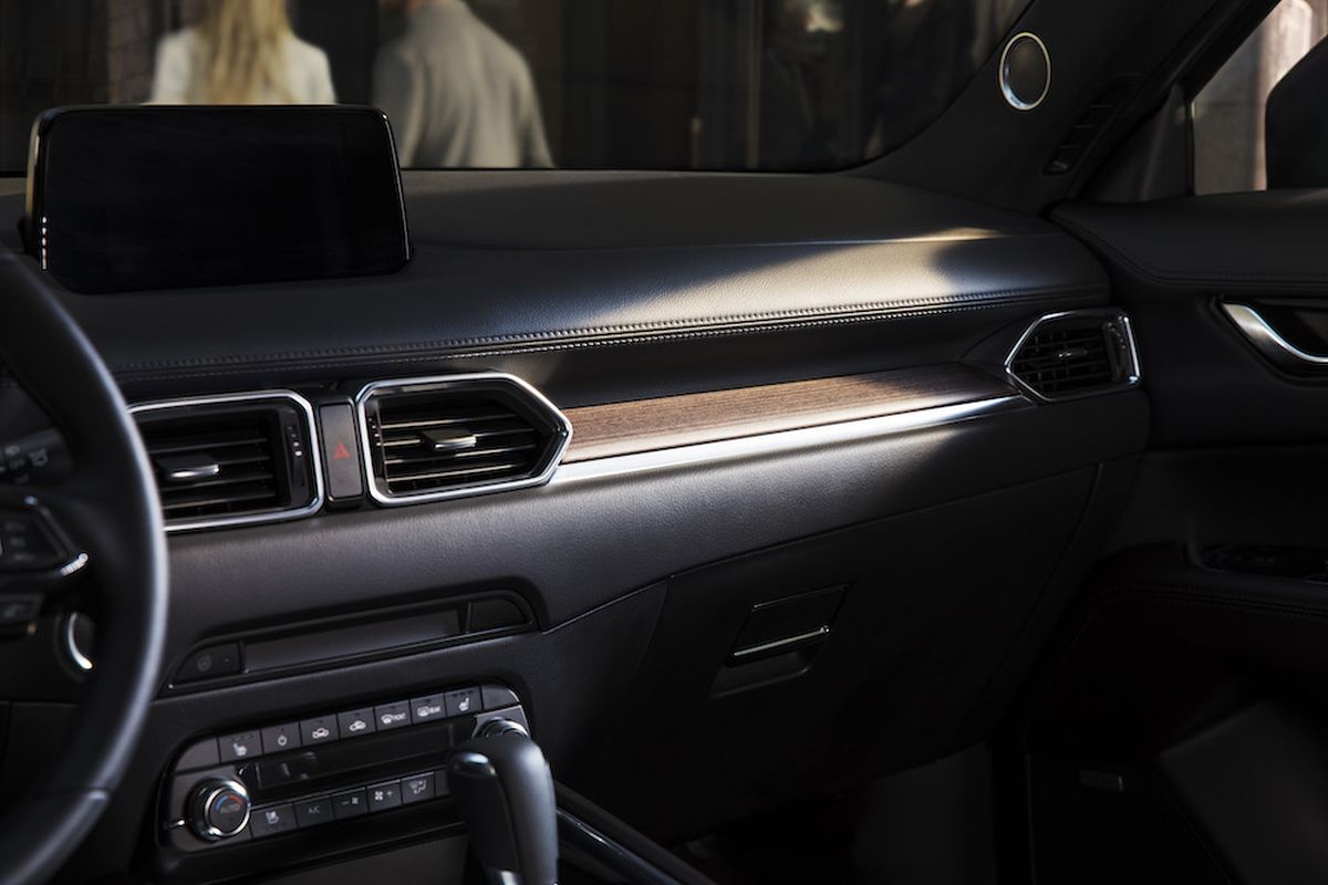Inside, Mazda’s less-is-more design strategy and agreeable infotainment interface cut cabin clutter. The thin, tiered dash is adorned only by a quartet of pentagonal vents. Stitched and textured soft-touch surfaces blanket the dash and door panels. (Mazda)