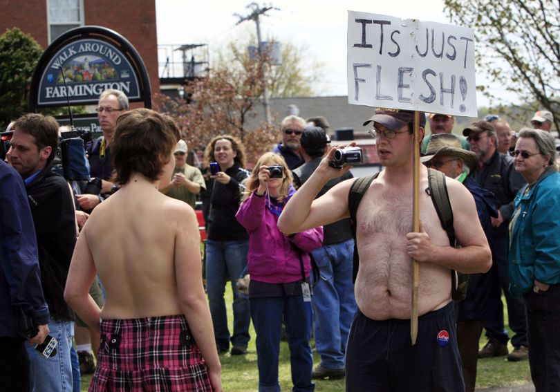 University of Maine at Farmington student Andrea Simoneau, left, is videotaped during a topless protest Friday, April 30, 2010, in Farmington, Maine. The demonstration called attention to the double-standard that it's acceptable for men, but not women, to go bare chested. In Maine, it's perfectly legal for women to go topless in public. (Robert Bukaty / Associated Press)