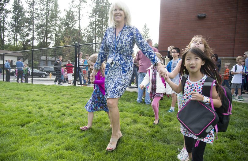 First-grade teacher Trish Campbell leads some of her students outside to find their buses after school Monday at Hutton Elementary. (Jesse Tinsley)