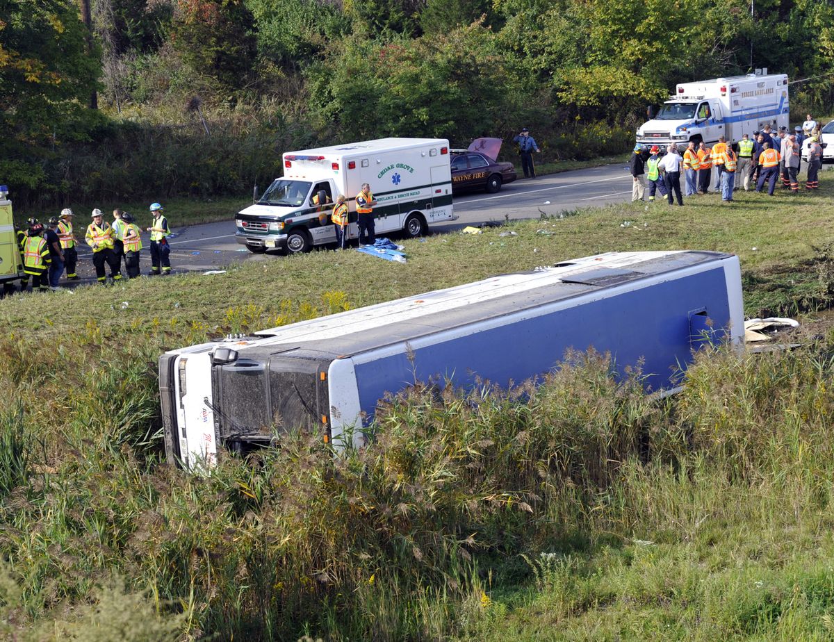 Rescue workers stand by after a bus overturned in a ditch at an exit ramp off Route 80 in Wayne, N.J. Saturday, Oct. 6, 2012. The chartered tour bus from Toronto carrying about 60 people overturned on an interstate exit ramp. Three people have been taken to hospital with non-life-threatening injuries. (Bill Kostroun / Fr51951 Ap)