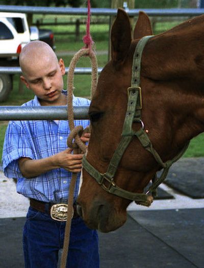 
Dylan Corbin, a 10-year-old Valleyford boy battling a relapse of leukemia, pets a horse named Sly, a polo horse owned by Suzy Dix of Spokane. 
 (Courtesy of suzy dix / The Spokesman-Review)