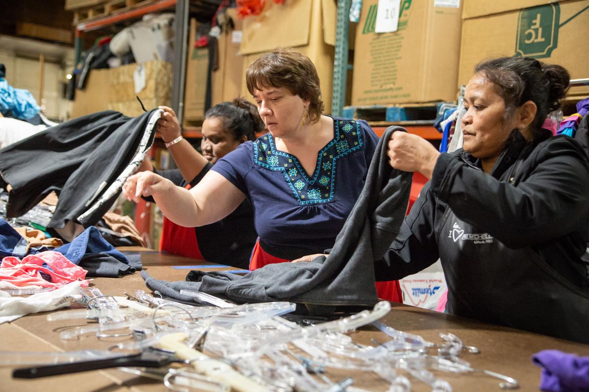 From left, Clanda Claney, of the Marshall Islands; Olha Malko, of the Ukraine; and Matlade Masumoto, of the Marshall Islands, work May 22, 2019, in the back room of Global Neighborhood Thrift, 919 E. Trent Ave. (Libby Kamrowski / The Spokesman-Review)